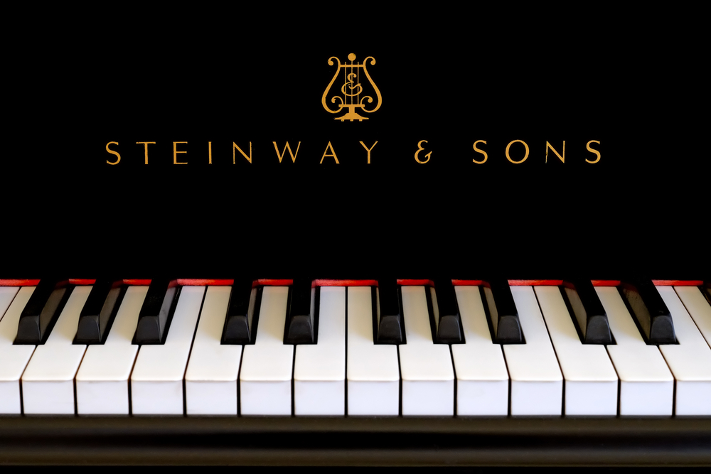 Steinway-Sons-logo-close-up.-Classic-gold-lettering-above-the-piano-keys-of-a-ebony-black-Steinway-grand-piano-1.jpg